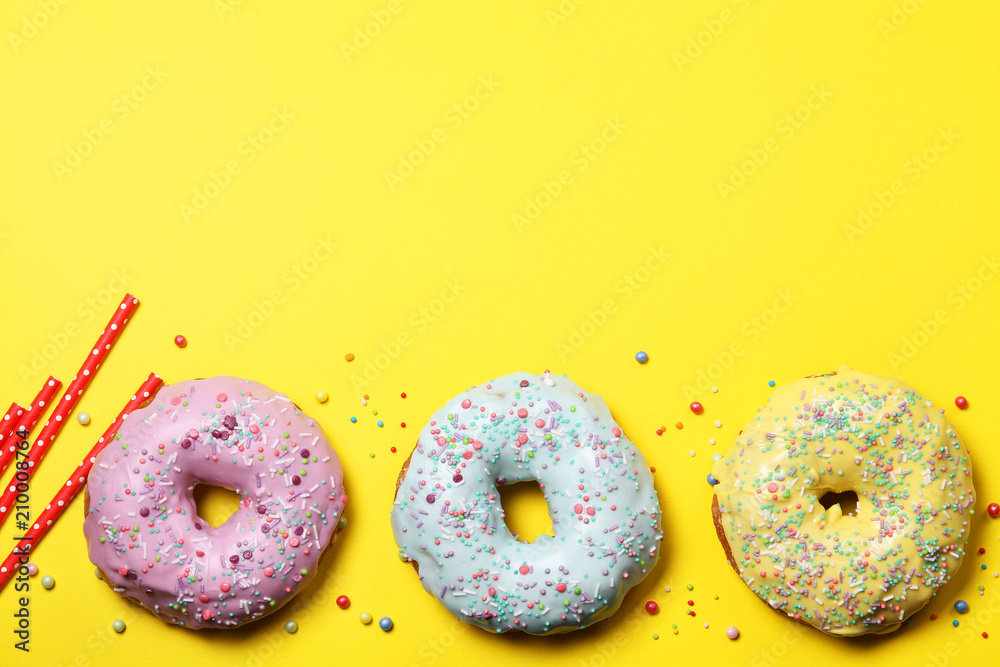 Glazed donuts and tinsel on a yellow background Glazed donuts and tinsel on a yellow background