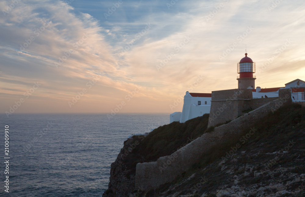  Portugal,  Algarve, Sagres, Cabo de S.Vicente. Silhouette of the famous lighthouse on the edge of the European continent against the background of the setting sun with pink clouds