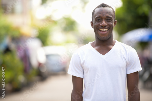 Young happy African man smiling in the streets outdoors