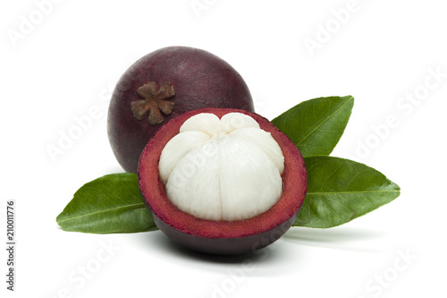 Mangosteen on white background, isolated whole exotic tropical fruit and another cut in half with green leaves, healthy food 