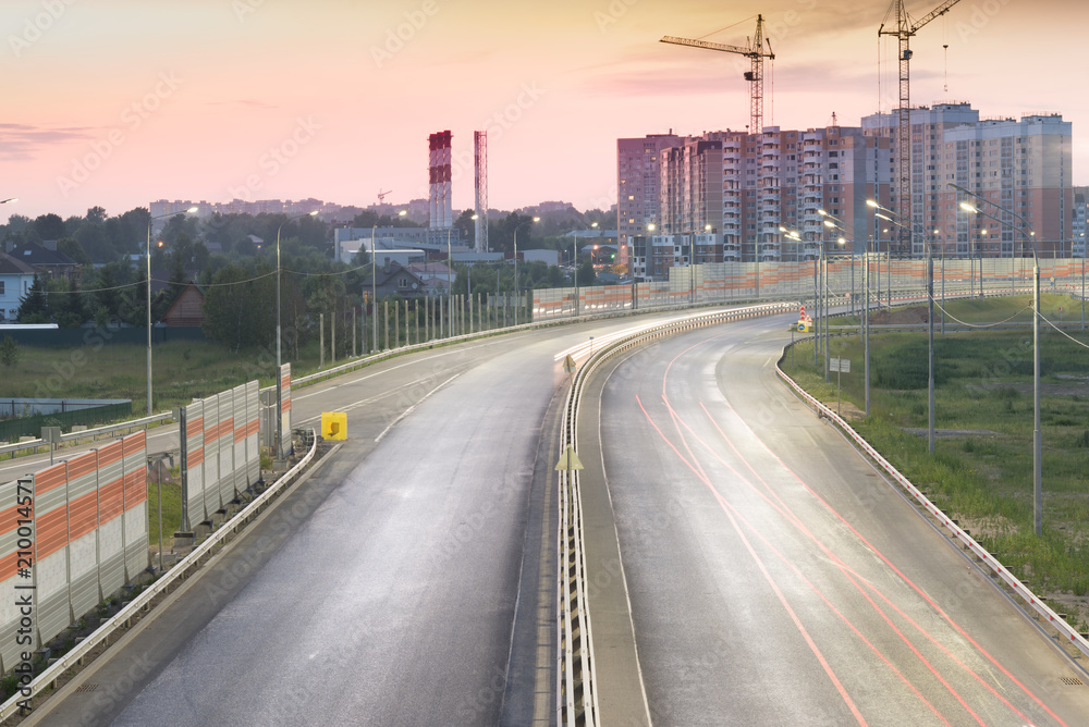 Traffic light trail on the road with accoustic barrier. Central ring road in Zvenigorod city. Moscow region Russia.