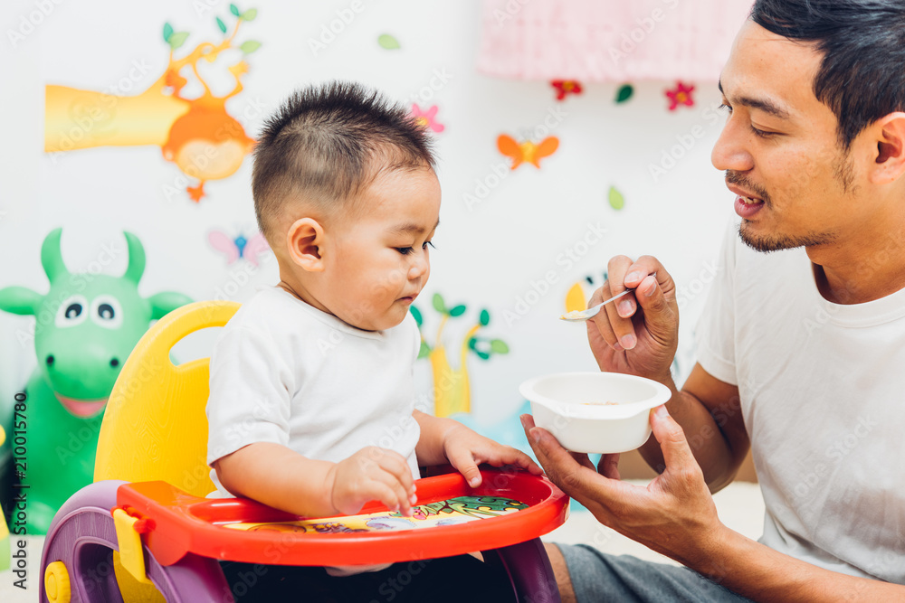 Father dad eating feed baby boy son Father dad eating feed baby boy son