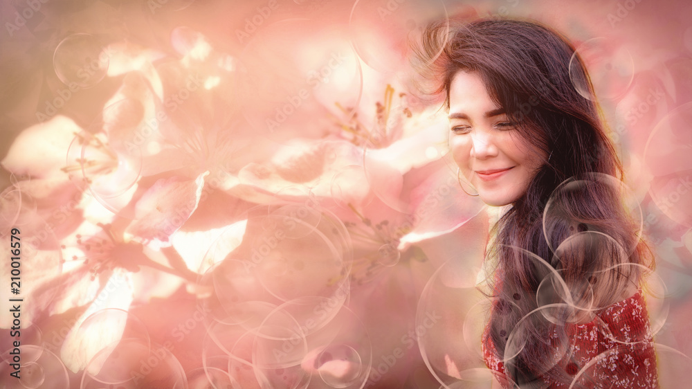 soft dreamy look image of beautiful young asian woman show happy face with fresh feeling with pinky soft background of flowers and foreground of floating bubles