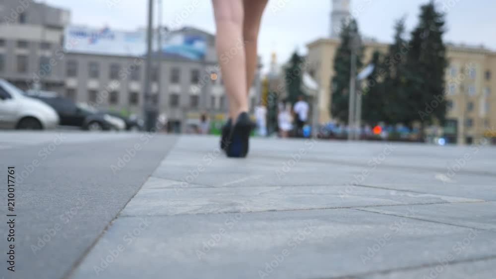Female legs in high heels shoes walking in the urban street near the camera. Feet of young business woman in high-heeled footwear going in the city. Girl stepping to work. Slow motion Close up Female legs in high heels shoes walking in the urban street near the camera. Feet of young business woman in high-heeled footwear going in the city. Girl stepping to work. Slow motion Close up