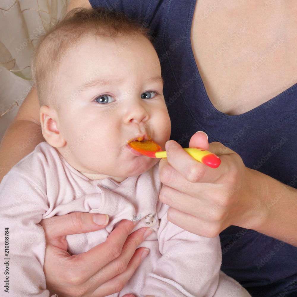 Mother and child - Baby eats from a spoon Mother and child - Baby eats from a spoon