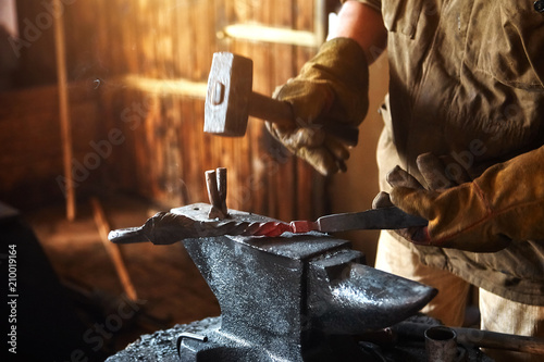 Blacksmith working on metal on anvil at forge high speed detail