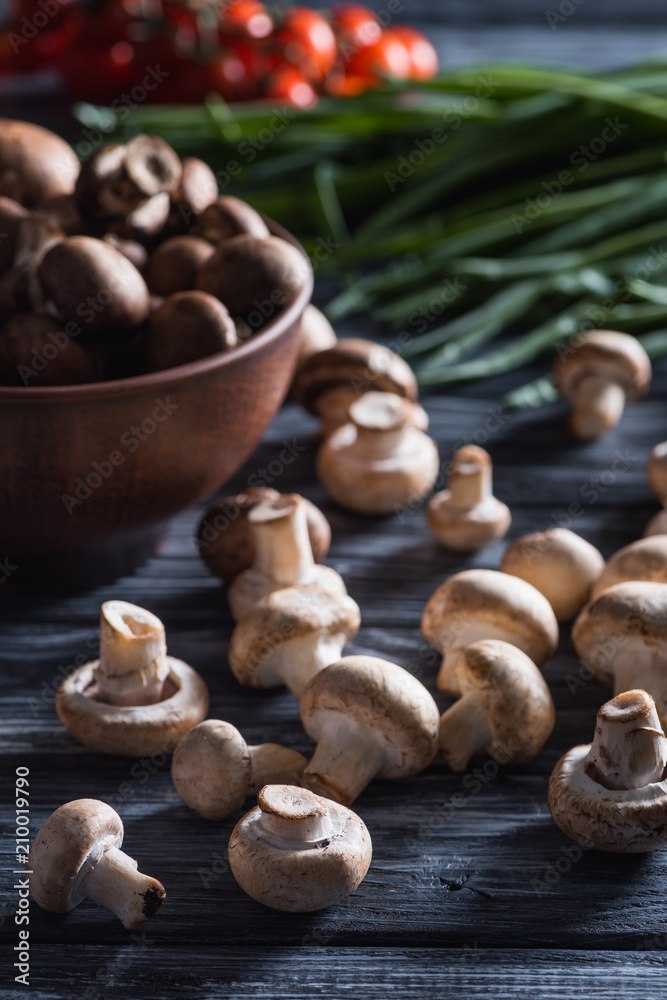 close-up shot of delicious raw champignon mushrooms with leek on dark wooden table close-up shot of delicious raw champignon mushrooms with leek on dark wooden table