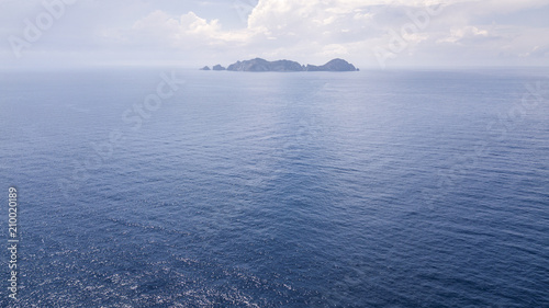 Aerial view of the island of Palmarola  in the archipelago of the Ponziane Islands west of Ponza  in the Tyrrhenian Sea  in Italy. The blue sea is calm and the sky is clear with few clouds.