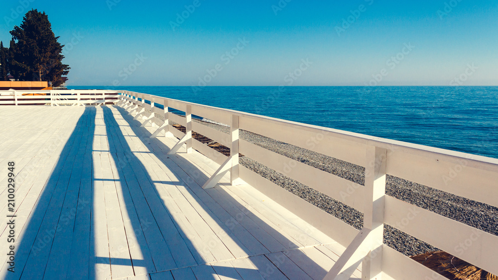 White wooden promenade by the sea. Minimalistic travel concept.