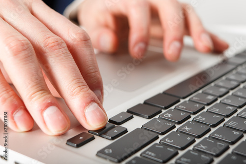 Close-up of hands businessman working at computer in office.