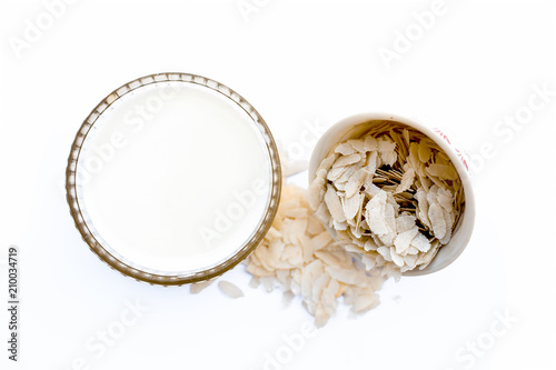 Ingredients of Poha kheer i.e. milk with flattened rice and sugar in a bowl isolated on white. photo