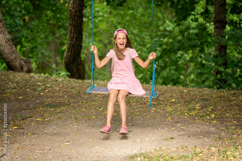 Laughing girl on a tree swings Laughing girl on a tree swings