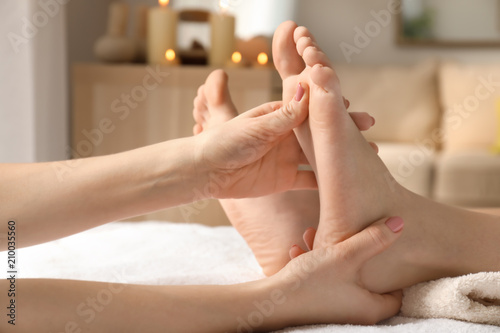 Beautiful young woman receiving foot massage in spa salon