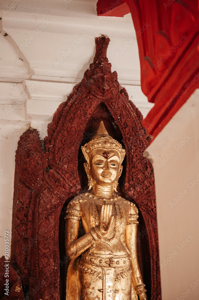 Fototapeta premium Old golden Buddha sculpture at Wat Phra Mahathat Nakhon Si Thammarat, Thailand
