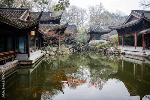 traditional chinese architecture and tea house reflecting on a pond with red carps (translation: tea house)