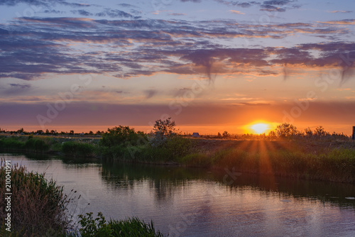 Silence, sunset in the steppe, beautiful clouds and the water surface of the canal. © Gennadiy