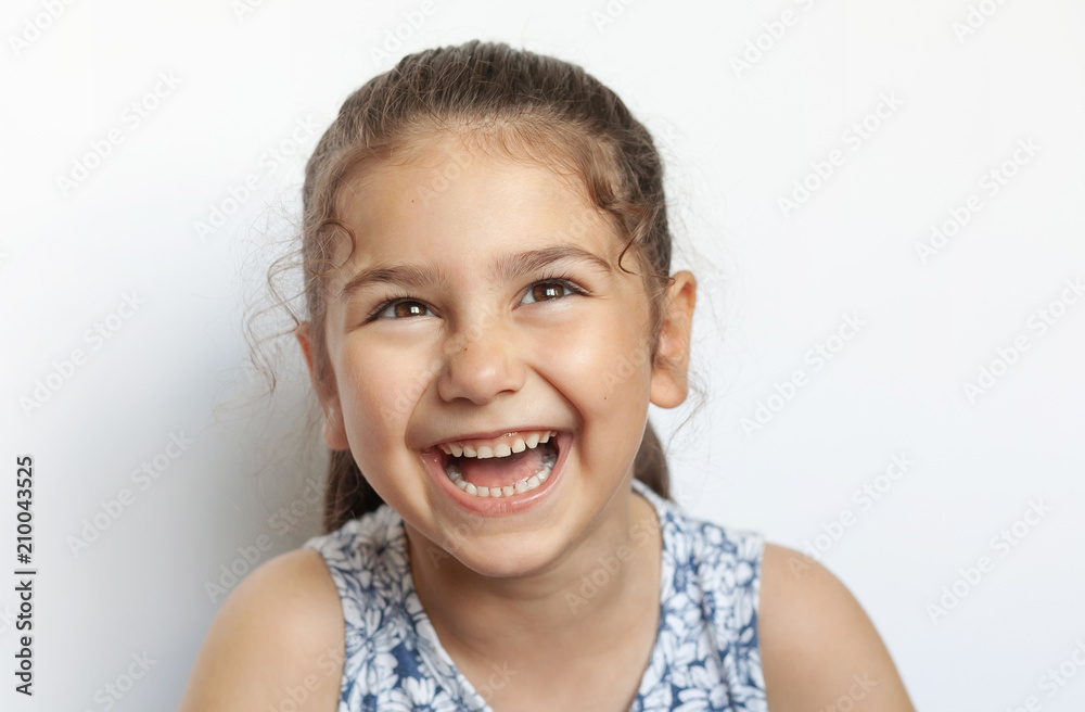 Portrait of a happy laughing child girl. Smiling child. Expressive facial expressions. Portrait of a happy laughing child girl. Smiling child. Expressive facial expressions.