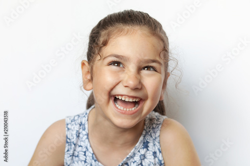 Portrait of a happy laughing child girl. Smiling child. Expressive facial expressions.