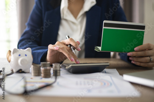 women checking amount in bank account passbook with bank statement.