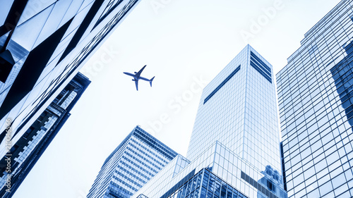 a plane flying over modern buildings of New York City