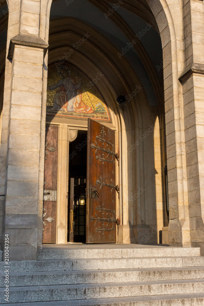Open doorway to medieval catholic church. Gothic cathedral exterior. Open church entrance. Religion concept. 