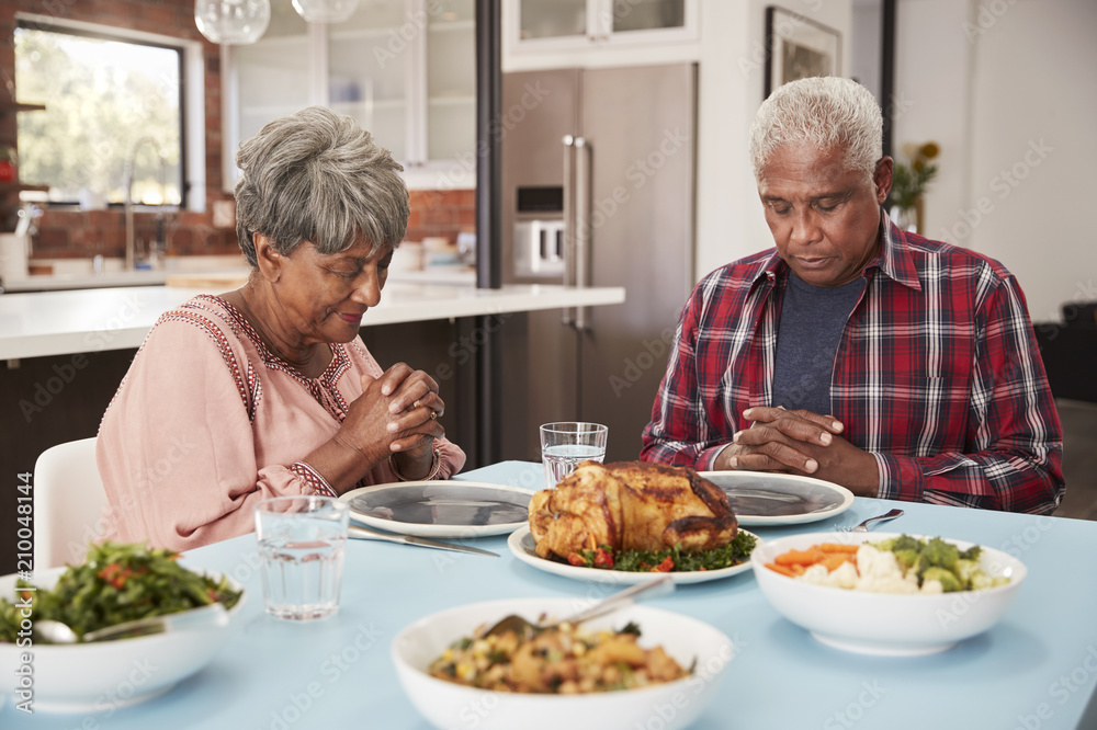 Senior Couple Saying Grace Before Meal Around Table At Home Senior Couple Saying Grace Before Meal Around Table At Home