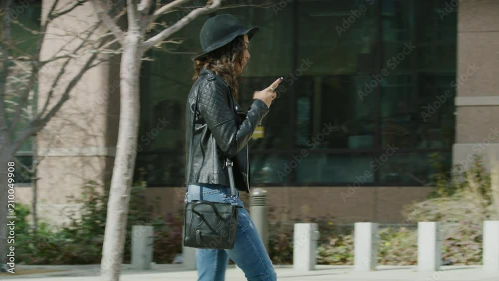 Slow motion shot of distracted woman texting on cell phone walking into post on sidewalk / Salt Lake City, Utah, United States Slow motion shot of distracted woman texting on cell phone walking into post on sidewalk / Salt Lake City, Utah, United States