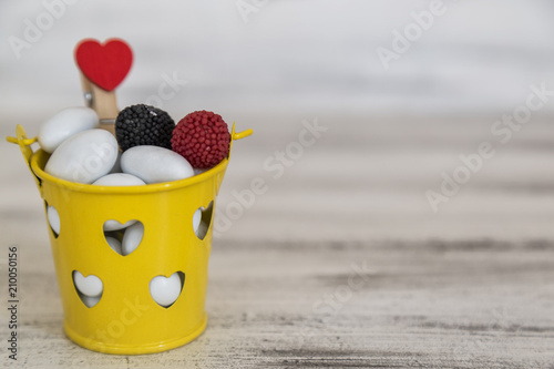 candies in a yellow hearted bucket. Romantic concept. candy feast . space for text .