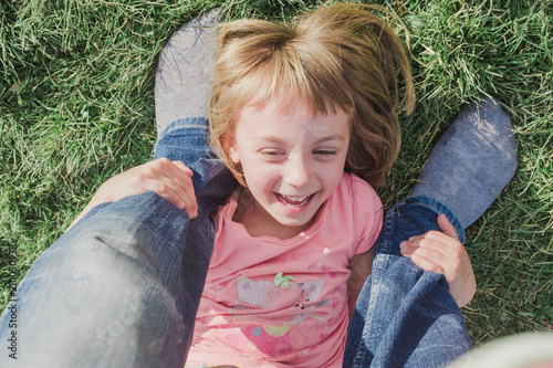 Toddler holding father's legs happily