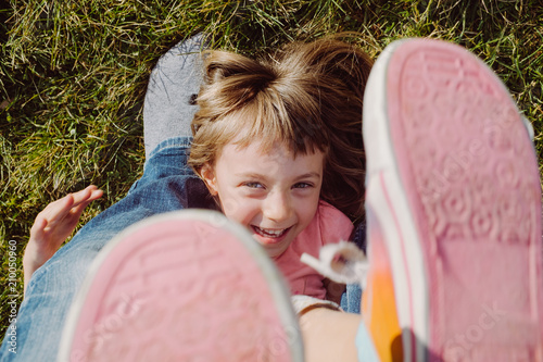 Toddler laying on grass kicking feet