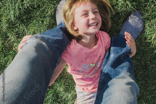 Toddler holding father's legs happily