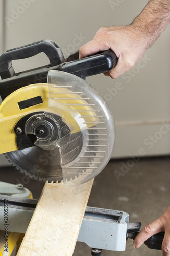 carpenter cutting with electric sawdust