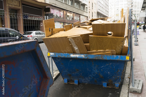 metal container with debris and wood waste in city street © GDM photo and video