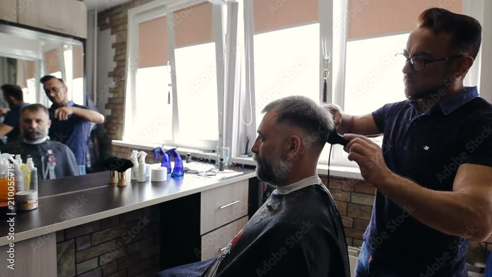 Hairdresser cuts client's hair in the Barber shop Hairdresser cuts client's hair in the Barber shop