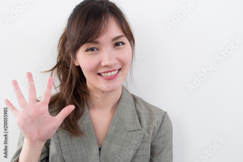 asian business woman pointing five fingers, 5 points; portrait of positive happy smiling asian businesswoman pointing up five fingers, 5 points number; asian chinese adult woman model business theme