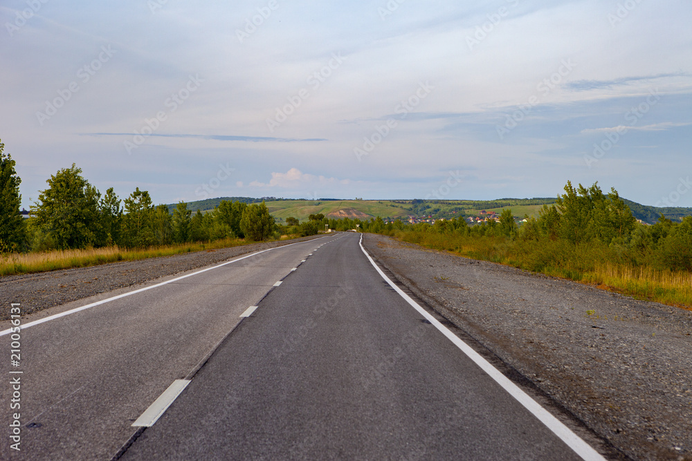 An empty road leading to the village on the hills. An empty road leading to the village on the hills.