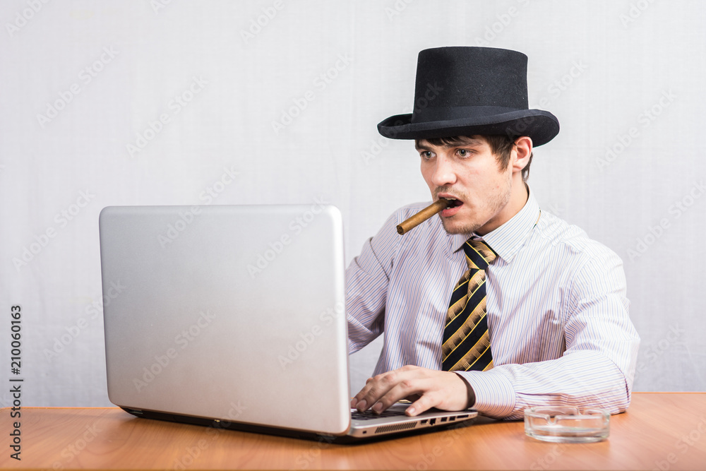 The guy in the top hat is wearing a shirt and tie is smoking a cigar The guy in the top hat is wearing a shirt and tie is smoking a cigar