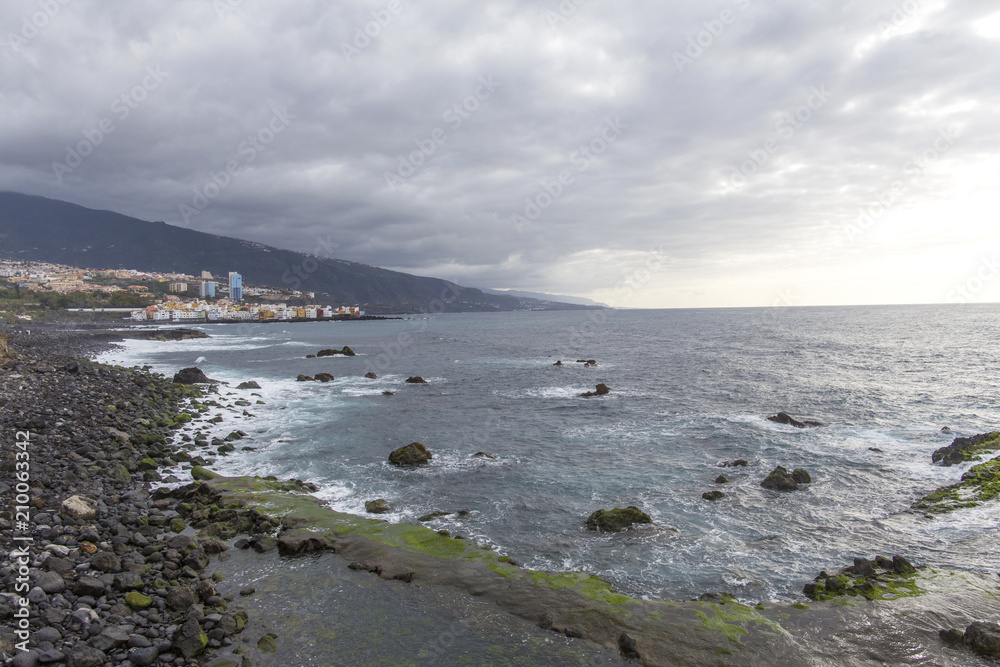 Puerto de la Cruz, Tenerife, Canary Islands - view of colorful houses, sea and volcanic-sand beach. Black beach in tenerife Puerto de la Cruz, Tenerife, Canary Islands - view of colorful houses, sea and volcanic-sand beach. Black beach in tenerife