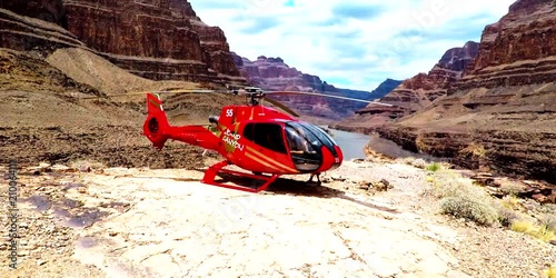 Model walking around a helicopter in the middle of the Grand Canyon