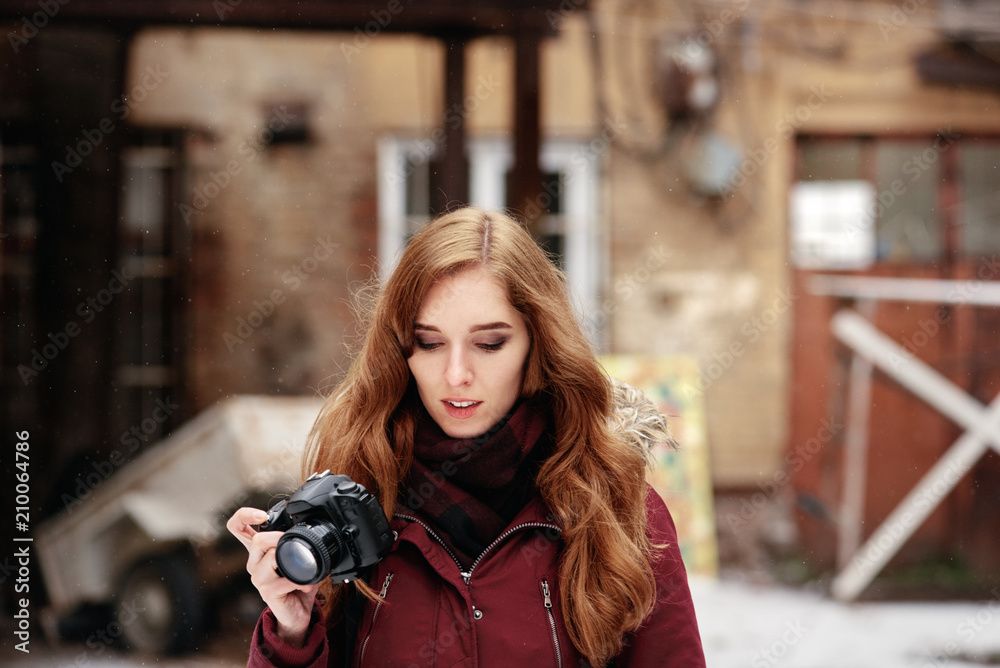 Portrait of beautiful red-haired photographer going on photo session