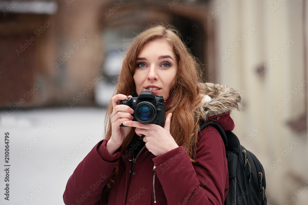 Portrait of woman photographer taking photos in winter city