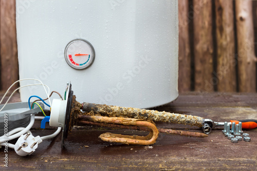 Fotografie broken water heater with heating elements, on wooden background
