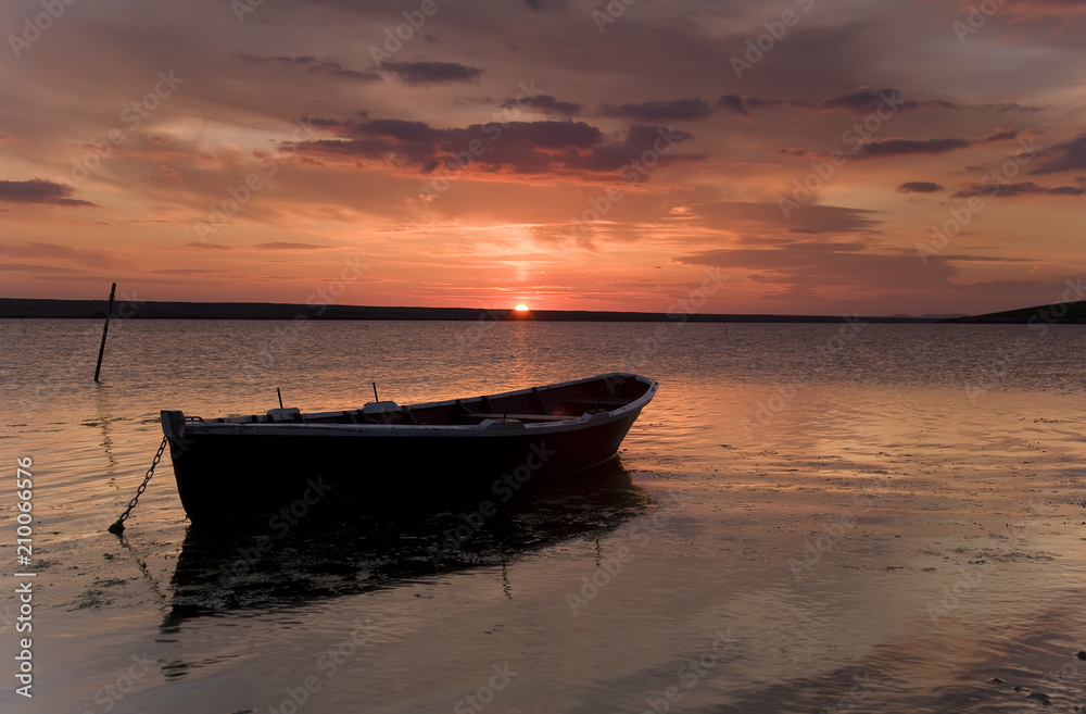 Fishing boat against orange sunset