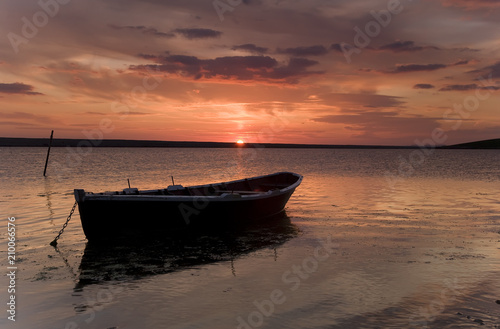 Fishing boat against orange sunset © Paul