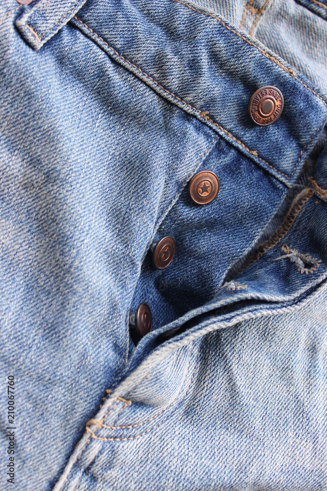 Details on denim pants, pocket and metal buttons, close-up. Free space for text Details on denim pants, pocket and metal buttons, close-up. Free space for text