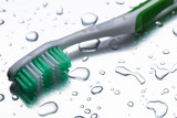 Green toothbrush on a gray background closeup