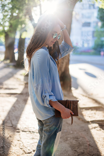 Girl is holding a clutch bag.