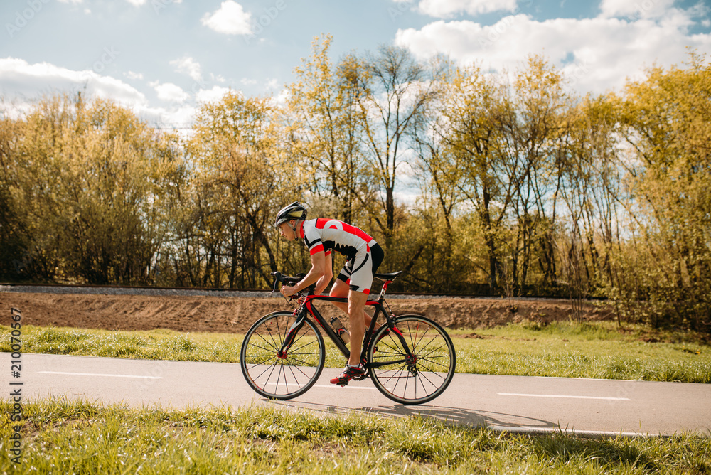 Obraz premium Cyclist rides on bicycle, side view