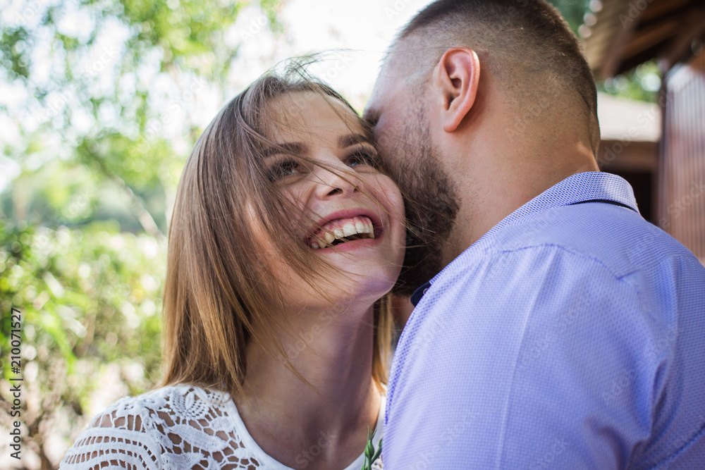 Young man whispering to woman or girlfriend, boyfriend telling surprising secret to his girl, man says nice words to his girlfriend, girl is smiling or laughing Young man whispering to woman or girlfriend, boyfriend telling surprising secret to his girl, man says nice words to his girlfriend, girl is smiling or laughing