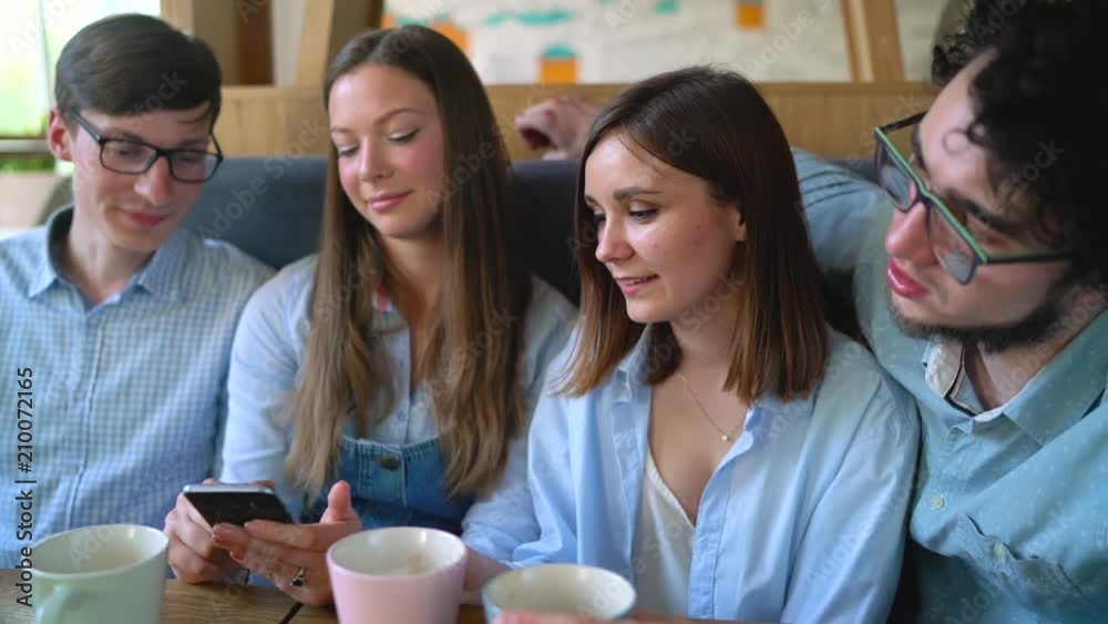 Young friends sit in a cafe, drink coffee and have fun communicating Young friends sit in a cafe, drink coffee and have fun communicating